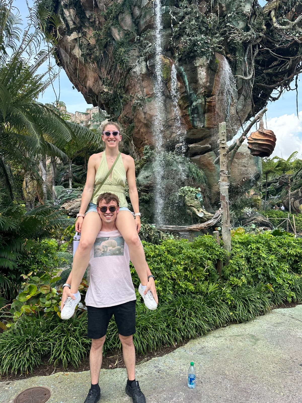 Jen on Luke's shoulders in front of the floating mountains at Disney World